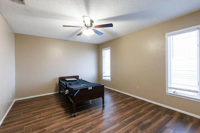 interior space featuring ceiling fan, a textured ceiling, and dark hardwood / wood-style flooring