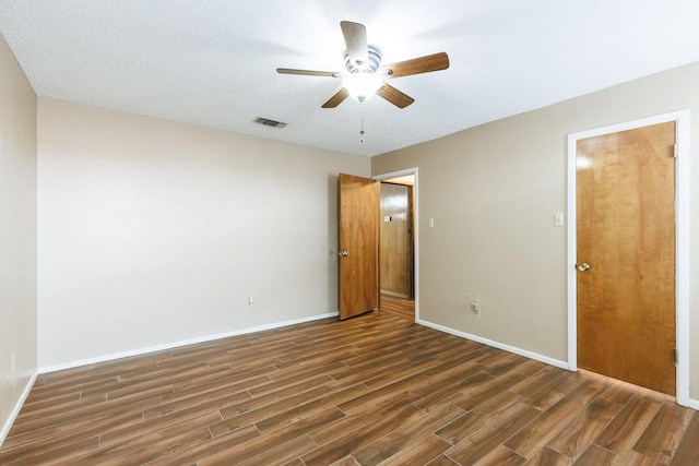 unfurnished room featuring dark wood-type flooring and ceiling fan