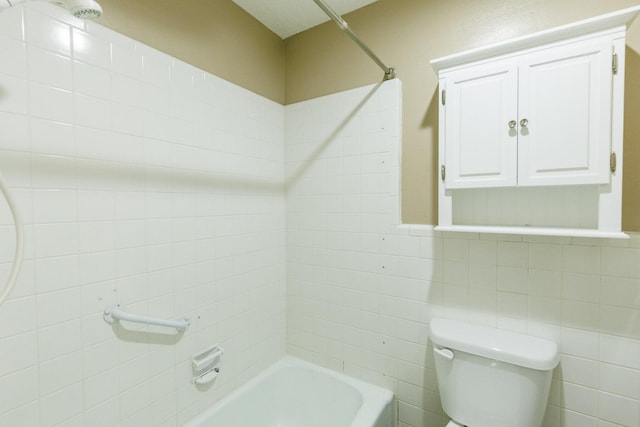 bathroom with tile walls, tiled shower / bath combo, and toilet