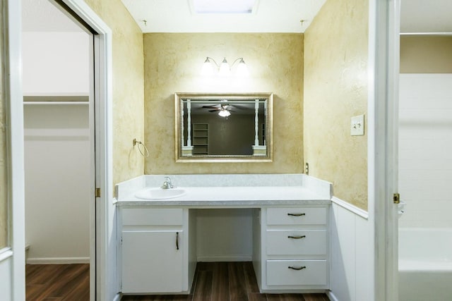 bathroom with vanity, hardwood / wood-style floors, and a washtub