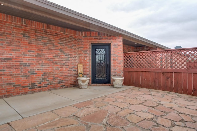 view of exterior entry featuring a patio