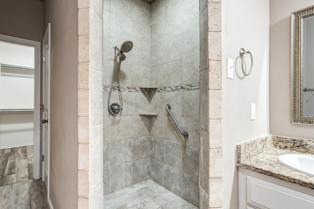 bathroom with vanity, wood-type flooring, and tiled shower