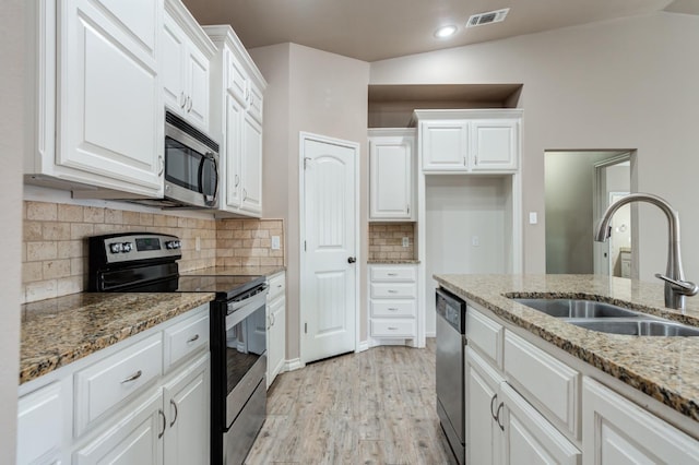 kitchen featuring white cabinetry, sink, light stone counters, stainless steel appliances, and light wood-type flooring