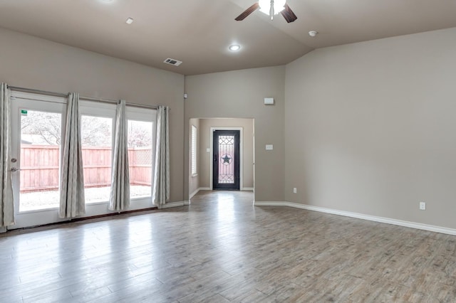 empty room with hardwood / wood-style floors, vaulted ceiling, and ceiling fan