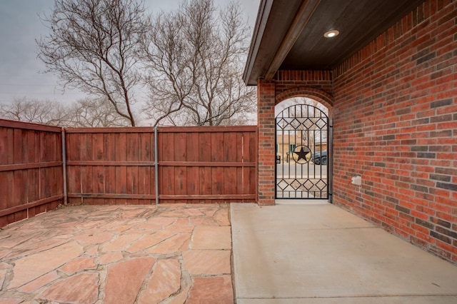 view of gate featuring a patio