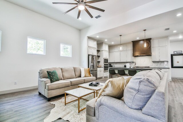 living room with ceiling fan and light wood-type flooring