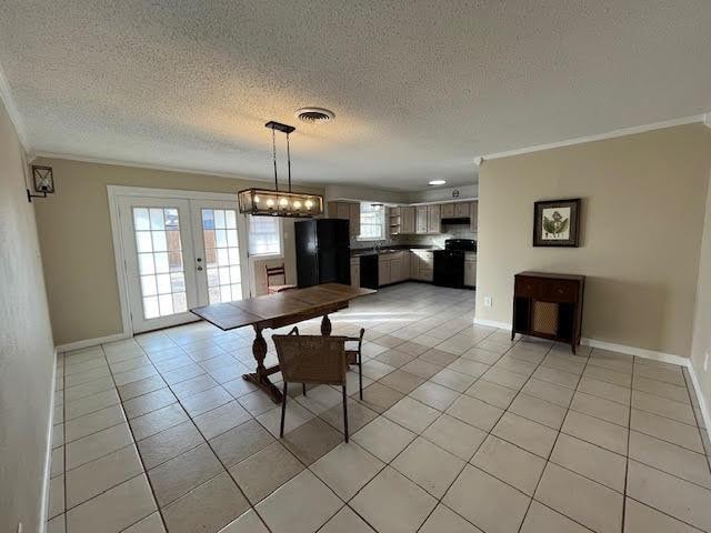 unfurnished dining area featuring crown molding, light tile patterned floors, a textured ceiling, and french doors