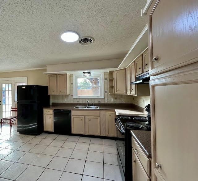 kitchen featuring sink, light brown cabinets, decorative backsplash, and black appliances