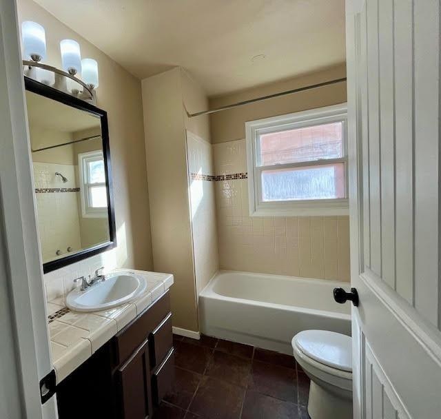 full bathroom with tiled shower / bath combo, vanity, tile patterned flooring, and toilet