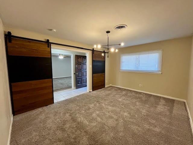 carpeted spare room with a barn door