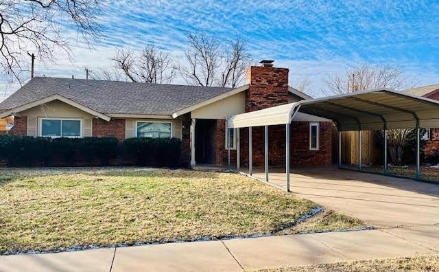 view of front of house with a front lawn and a carport