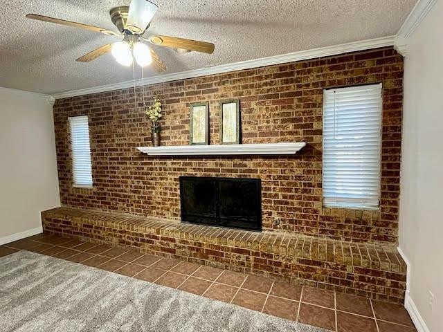 unfurnished living room featuring ornamental molding, a textured ceiling, dark tile patterned flooring, and a fireplace