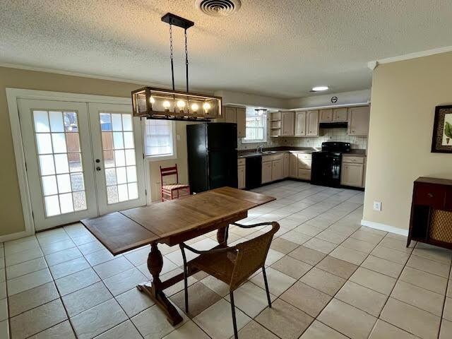 tiled dining room with sink, ornamental molding, french doors, and a textured ceiling