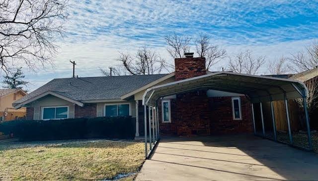 view of front facade with a front lawn and a carport