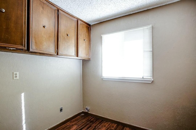 8206 Louisville Ave, Lubbock, TX 79423 - washroom with dark wood-type flooring, hookup for an electric dryer, and cabinet space