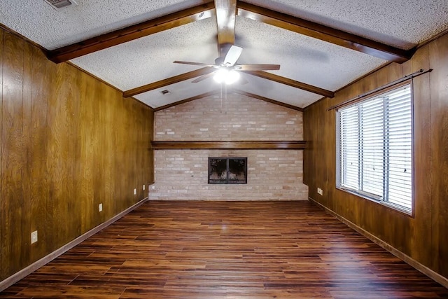 8206 Louisville Ave, Lubbock, TX 79423 - unfurnished living room featuring wood finished floors, ceiling fan, a textured ceiling, wooden walls, and a brick fireplace