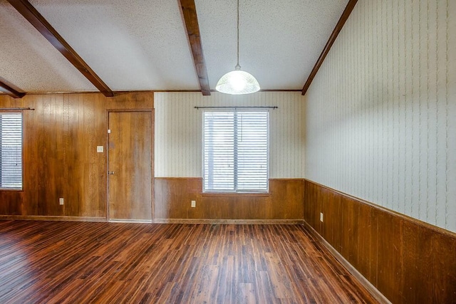 8206 Louisville Ave, Lubbock, TX 79423 - unfurnished room with a textured ceiling, beam ceiling, dark wood finished floors, and wood walls