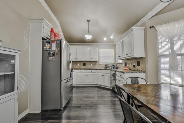 kitchen featuring ornamental molding, appliances with stainless steel finishes, light stone countertops, and white cabinets