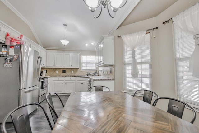 dining room featuring lofted ceiling, ornamental molding, and wood finished floors