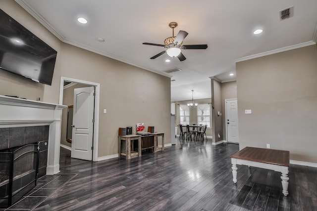 living room with ornamental molding, dark wood-type flooring, a tile fireplace, and visible vents