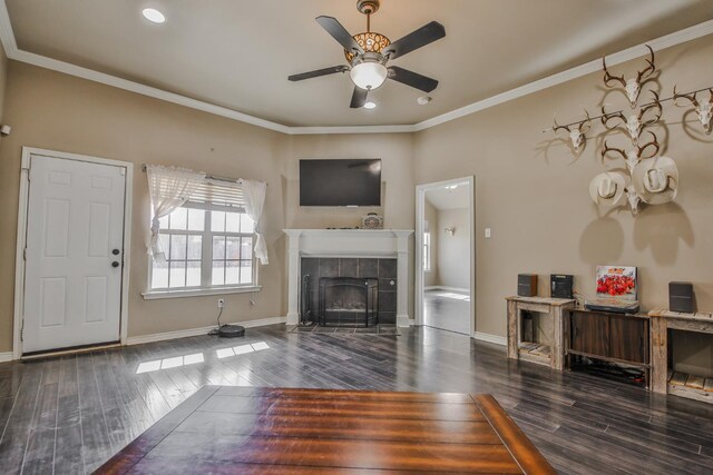 unfurnished living room with crown molding, a fireplace, dark hardwood / wood-style floors, and ceiling fan