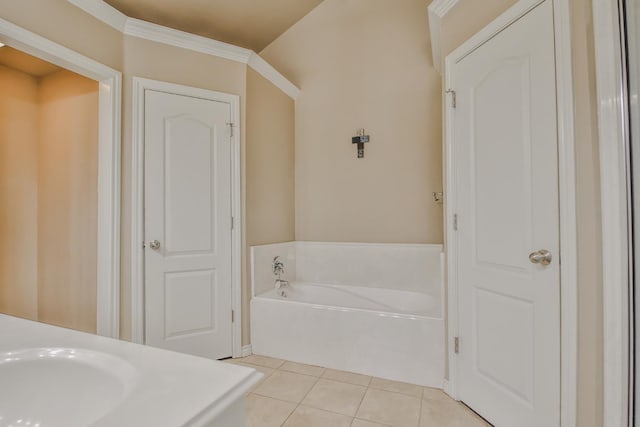 bathroom featuring a garden tub, ornamental molding, a sink, and tile patterned flooring