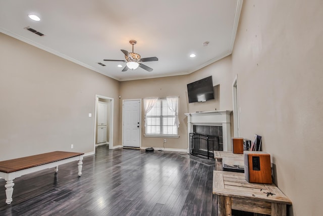 living room with a fireplace, visible vents, baseboards, dark wood finished floors, and crown molding