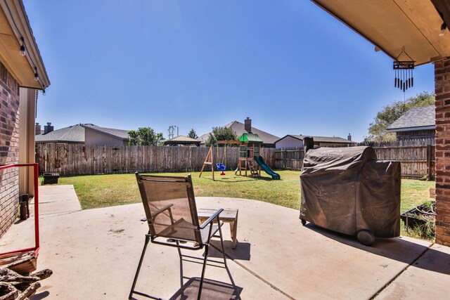 view of patio with a playground and a grill