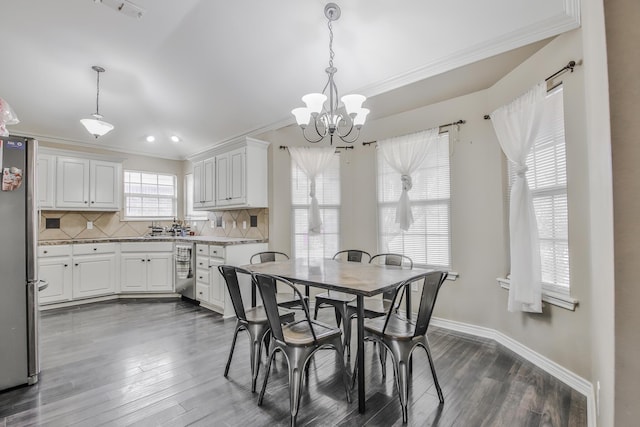 dining room featuring dark wood-style floors, baseboards, a chandelier, and crown molding