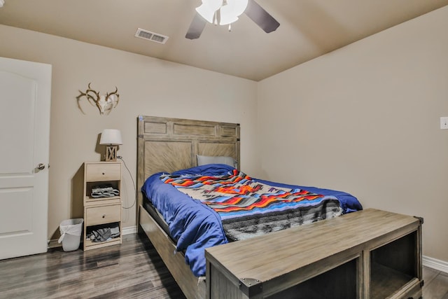 spare room featuring dark wood-style floors, visible vents, baseboards, and a ceiling fan