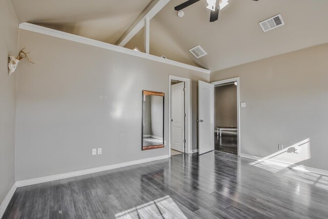 unfurnished bedroom featuring dark wood-type flooring, visible vents, vaulted ceiling, and baseboards