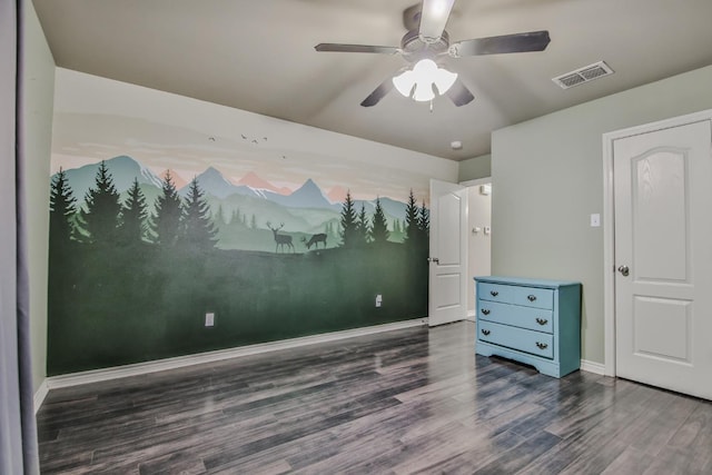 spare room with a ceiling fan, dark wood-style flooring, visible vents, and baseboards