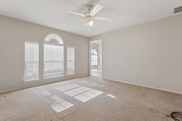 spare room with ceiling fan, light colored carpet, and a textured ceiling