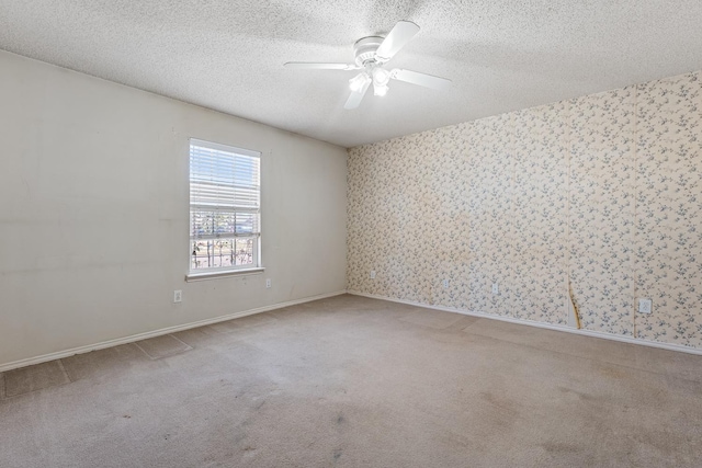 carpeted empty room with ceiling fan and a textured ceiling