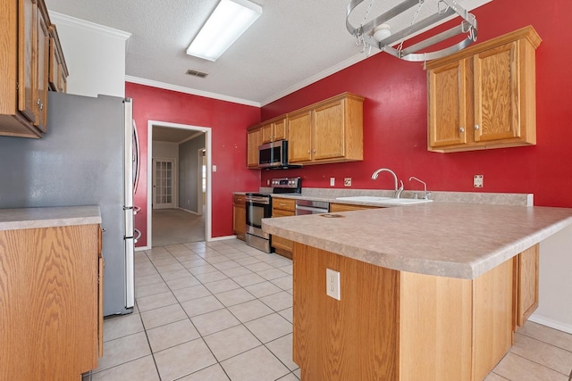 kitchen with appliances with stainless steel finishes, sink, light tile patterned floors, kitchen peninsula, and crown molding