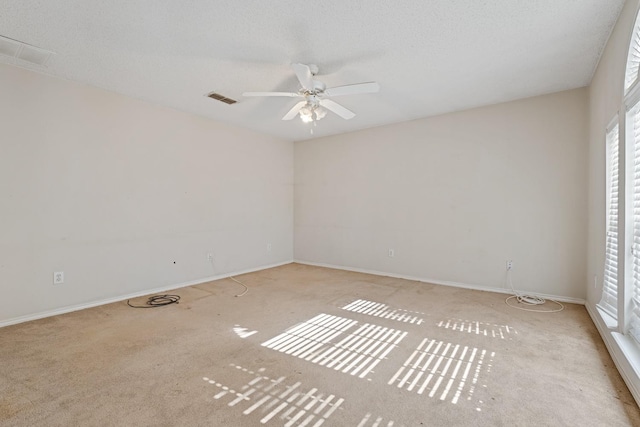 unfurnished room with light colored carpet, a textured ceiling, and ceiling fan