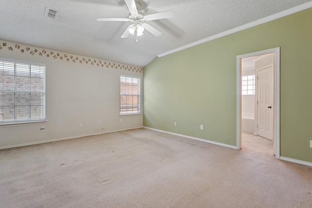 unfurnished room featuring ceiling fan, ornamental molding, a textured ceiling, light carpet, and vaulted ceiling