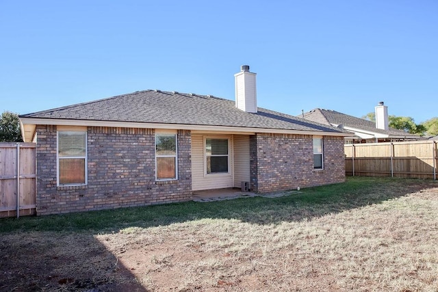 rear view of property featuring a lawn