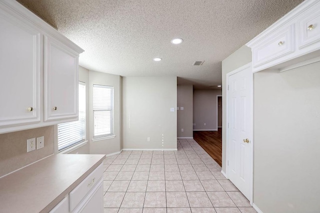 unfurnished dining area with light tile patterned floors and a textured ceiling