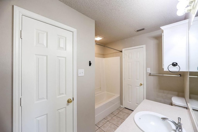 bathroom with tile patterned flooring, vanity, bathing tub / shower combination, and a textured ceiling