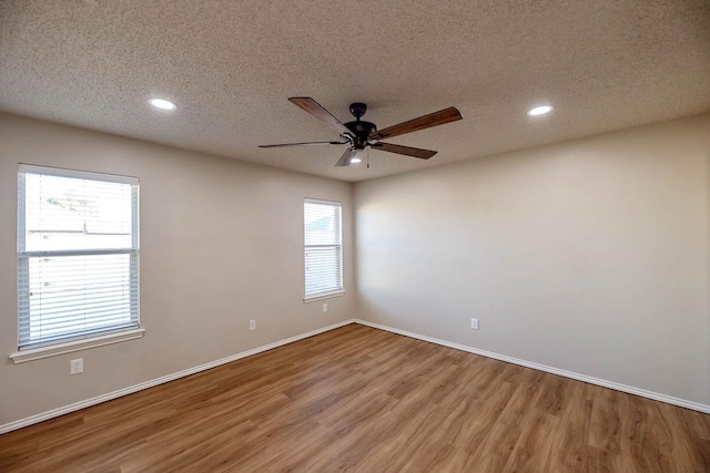 empty room featuring ceiling fan, light hardwood / wood-style flooring, and a textured ceiling