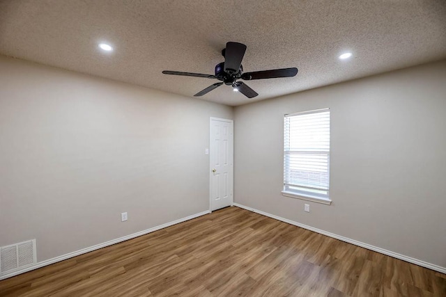 spare room with ceiling fan, wood-type flooring, and a textured ceiling