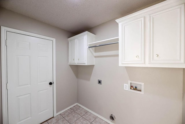 washroom featuring cabinets, a textured ceiling, light tile patterned floors, hookup for a washing machine, and hookup for an electric dryer