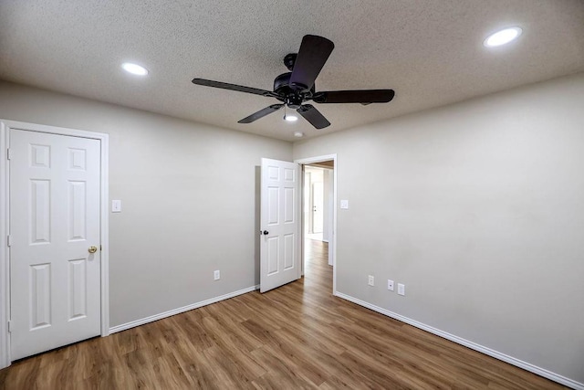 unfurnished bedroom with hardwood / wood-style flooring, a textured ceiling, and ceiling fan