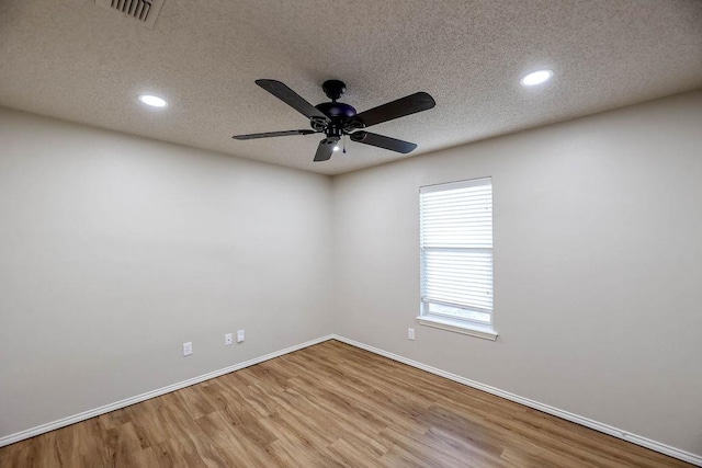 empty room with ceiling fan and light hardwood / wood-style floors