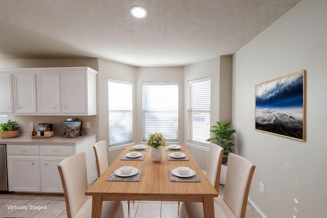 tiled dining space featuring a textured ceiling