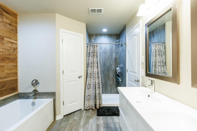 8812 16th St, Lubbock, TX 79416 - full bath with visible vents, vanity, wood finished floors, tiled shower, and a bathing tub