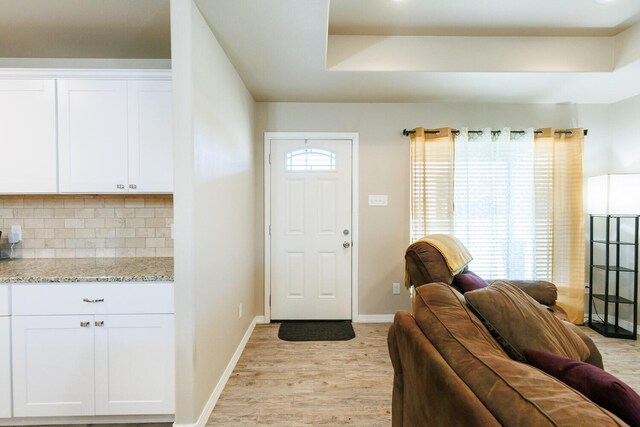 8812 16th St, Lubbock, TX 79416 - foyer with baseboards, light wood-style flooring, and a raised ceiling