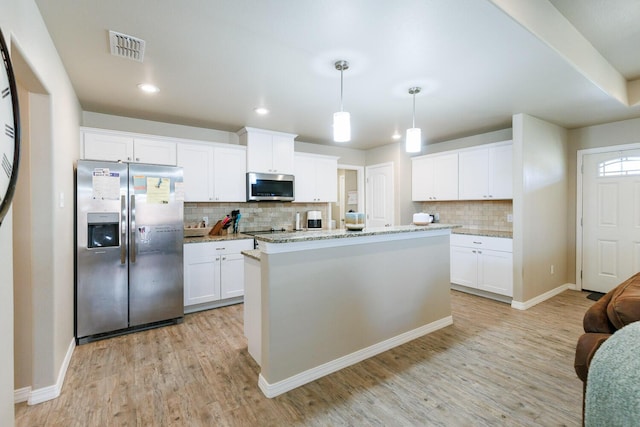 8812 16th St, Lubbock, TX 79416 - kitchen with light wood-type flooring, appliances with stainless steel finishes, visible vents, and tasteful backsplash