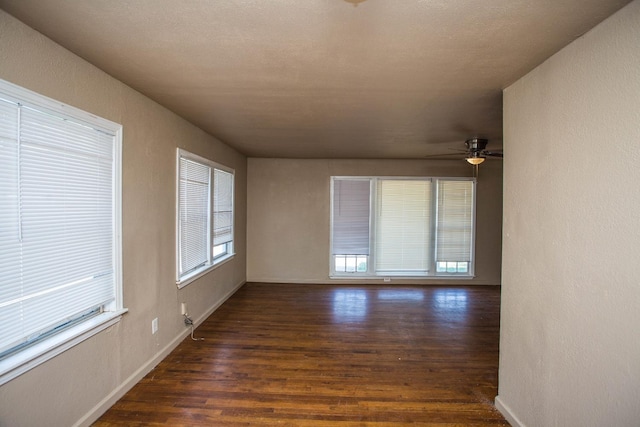 empty room featuring ceiling fan and dark hardwood / wood-style flooring